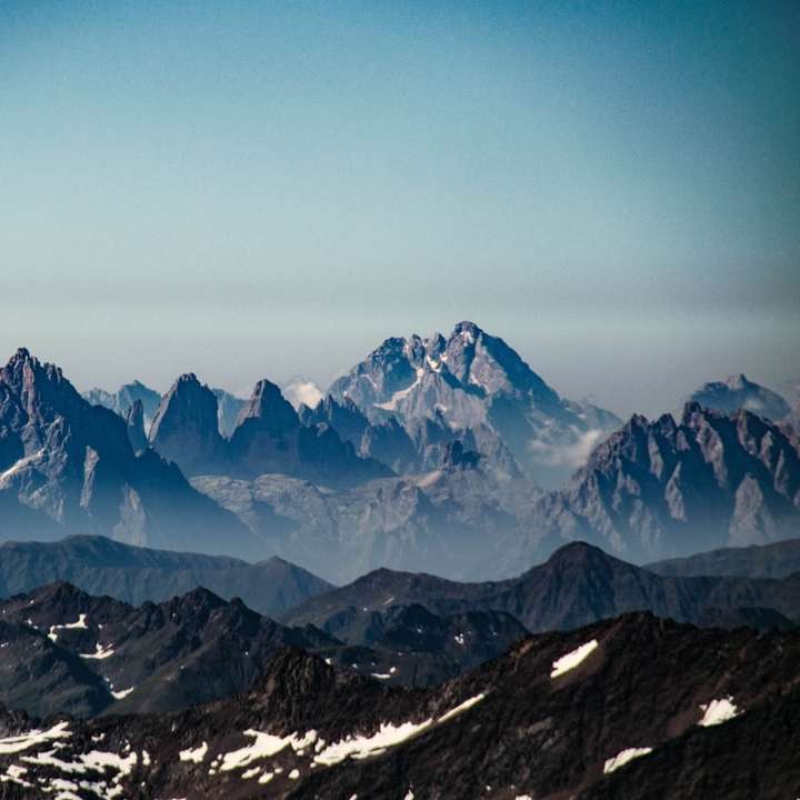 Montaña cubierta de nieve bajo un cielo azul durante el día puzzle deslizante online