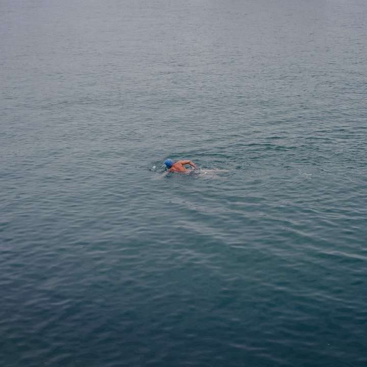 person som simmar på blå havet under dagtid Pussel online