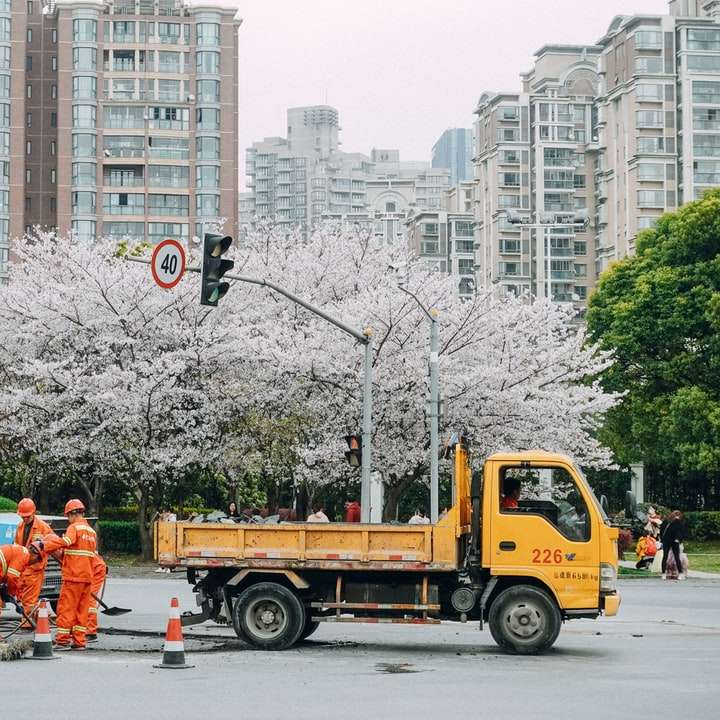 mensen in oranje jasje staande op besneeuwde weg online puzzel