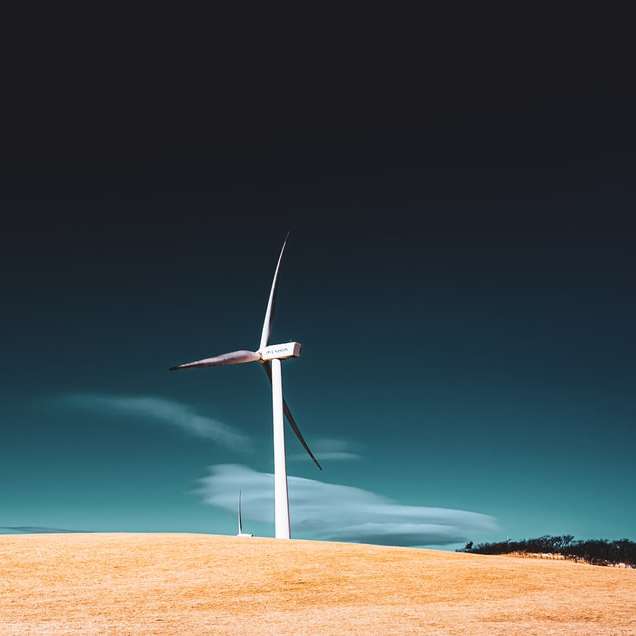 biała turbina wiatrowa na brązowym polu pod błękitnym niebem puzzle przesuwne online