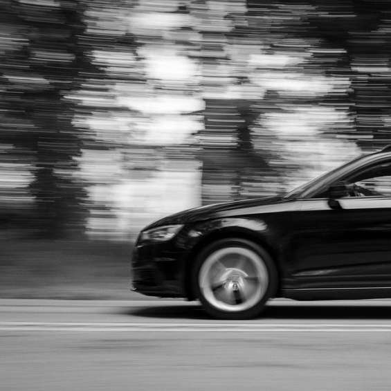 gråskalefoto av svart bil på väg Pussel online
