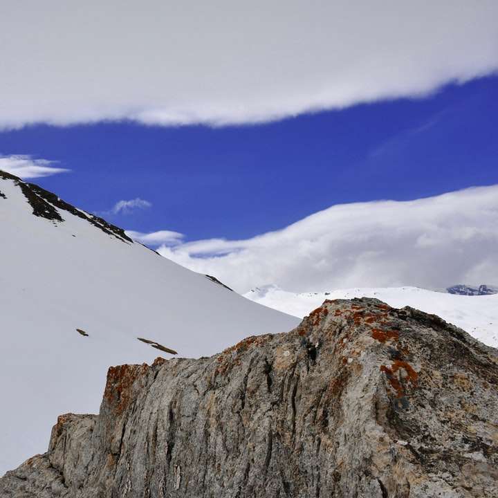 munte acoperit de zăpadă sub cer albastru în timpul zilei alunecare puzzle online