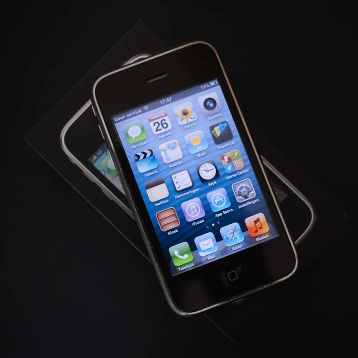 Svart iPhone 4 på vitt bord glidande pussel online