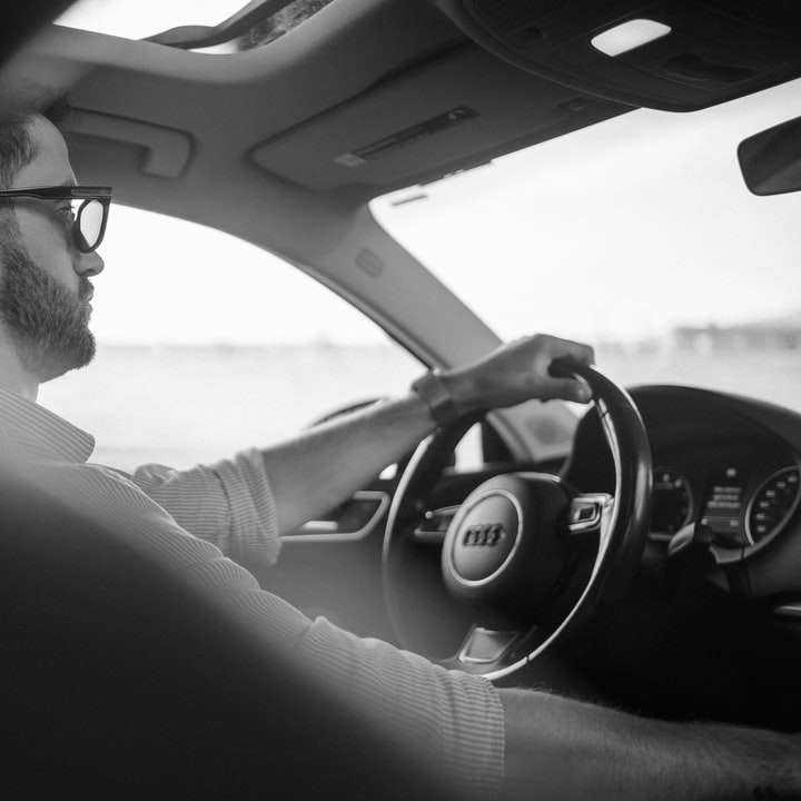 άνδρας με μαύρο πουκάμισο που οδηγεί αυτοκίνητο κατά τη διάρκεια της ημέρας online παζλ