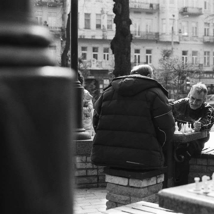 fotografie în tonuri de gri cu un bărbat și o femeie stând pe bancă puzzle online