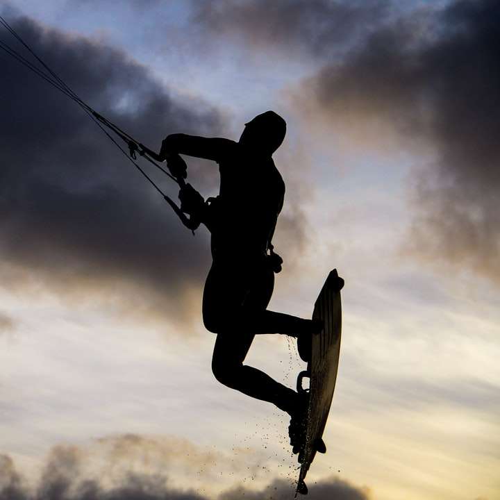 Silhouette eines Mannes, der unter bewölktem Himmel auf Skateboard reitet Online-Puzzle