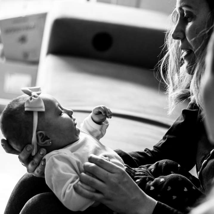 photo en niveaux de gris d'une femme portant un bébé puzzle en ligne