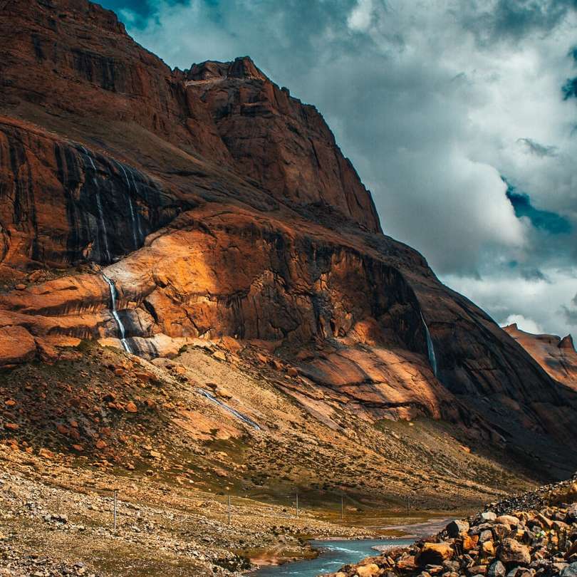 montagna rocciosa marrone sotto il cielo nuvoloso durante il giorno puzzle online