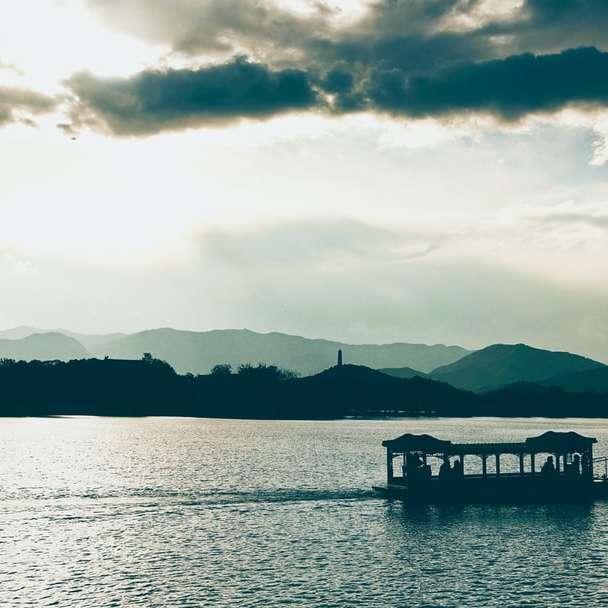 silhouet van persoon op boot op het water tijdens zonsondergang schuifpuzzel online
