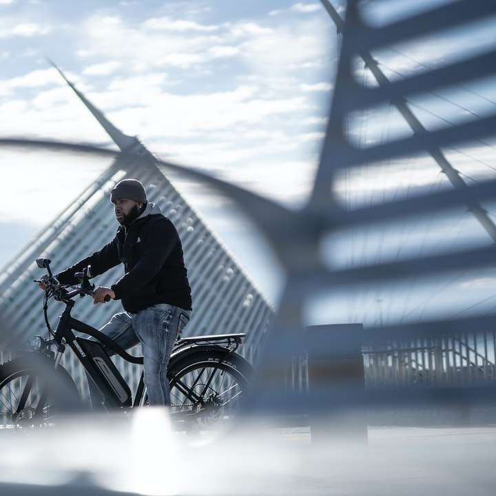 человек в черной куртке катается на велосипеде по заснеженной земле онлайн-пазл