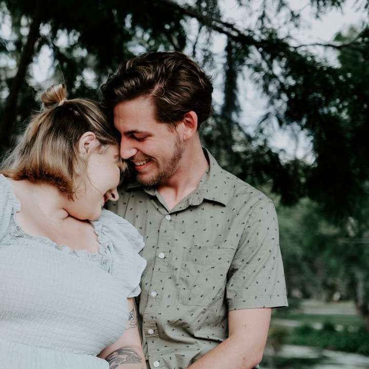 Hombre en camisa gris abotonada besando a una mujer en vestido blanco puzzle deslizante online