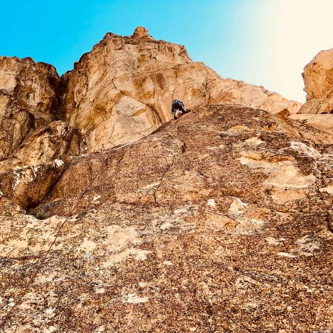 άτομο που σκαρφαλώνει στο βραχώδες βουνό κατά τη διάρκεια της ημέρας online παζλ