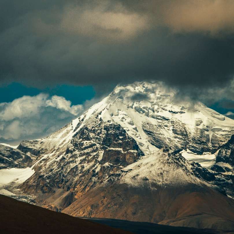заснежена планина под облачно небе през деня плъзгащ се пъзел онлайн