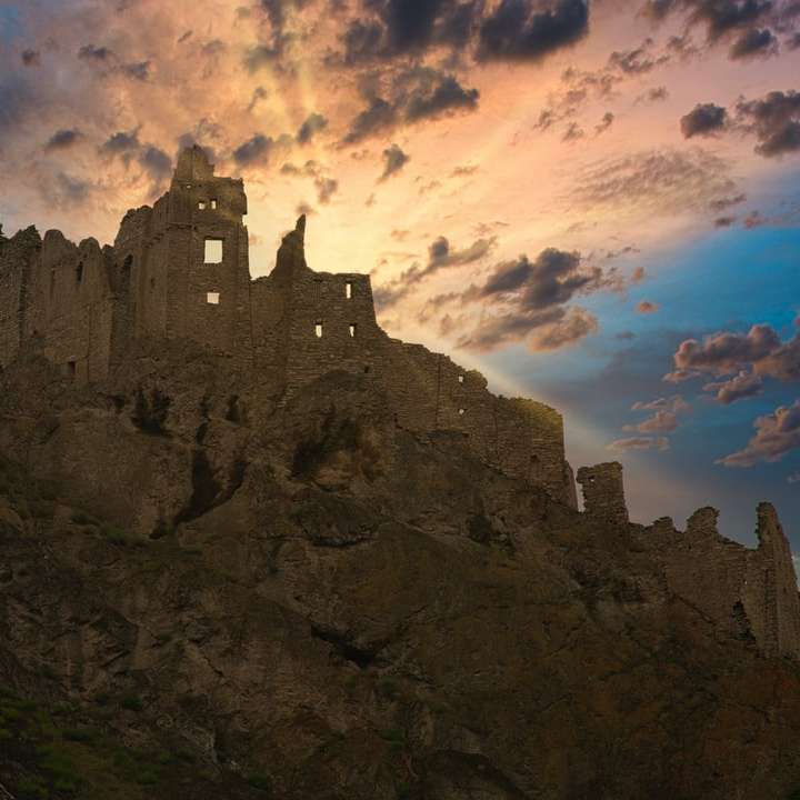 szary betonowy zamek pod błękitne niebo i białe chmury puzzle online