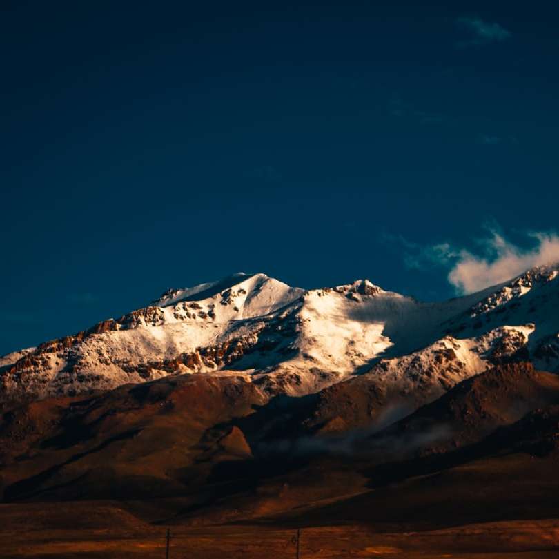 Montaña cubierta de nieve bajo un cielo azul durante el día rompecabezas en línea