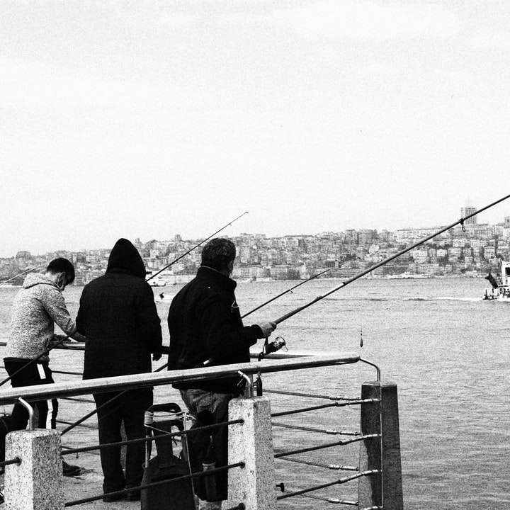 grayscale photo of people standing on boat sliding puzzle online