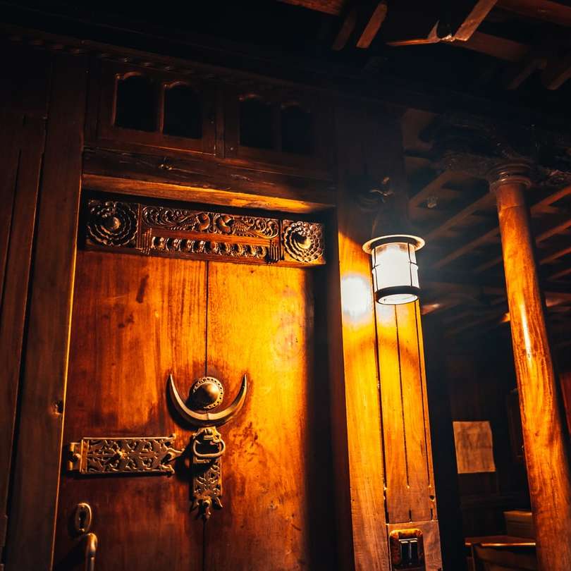 黒い鋼のドアレバーが付いている茶色の木製のドア オンラインパズル