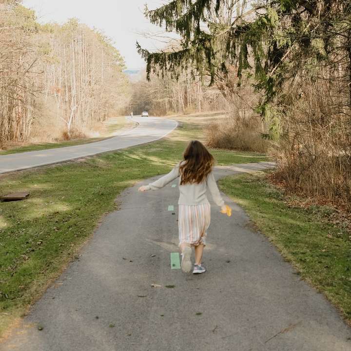 dziewczyna w białej koszuli chodząca po szarej asfaltowej drodze puzzle przesuwne online