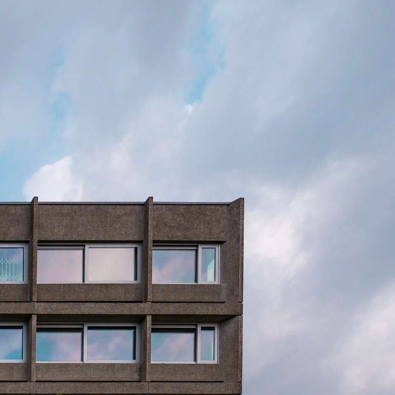 edifício de concreto azul e branco sob nuvens brancas puzzle online