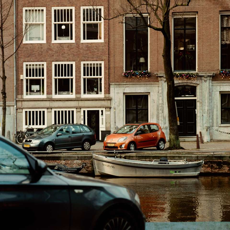 samochody zaparkowane przed brązowo-białym budynkiem puzzle przesuwne online