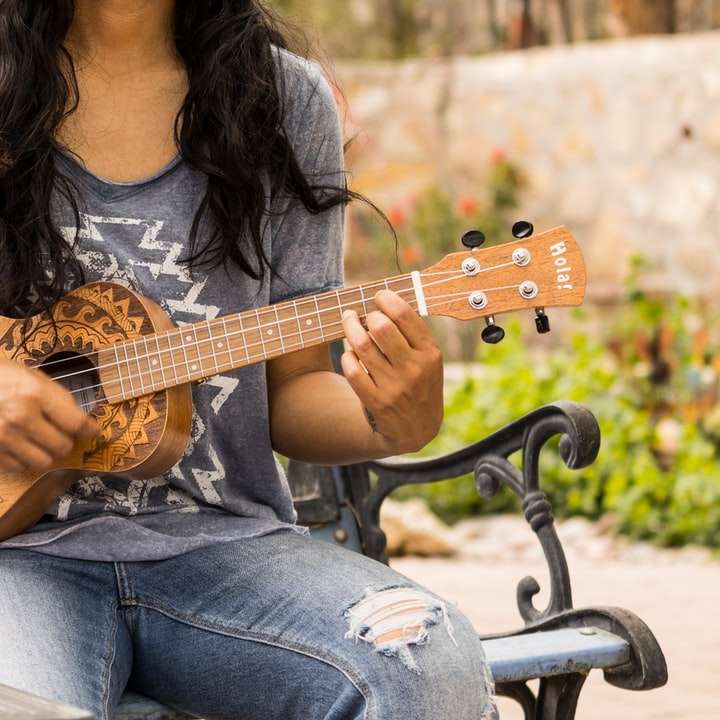 femme en chemise à manches longues marron jouant de la guitare acoustique puzzle en ligne