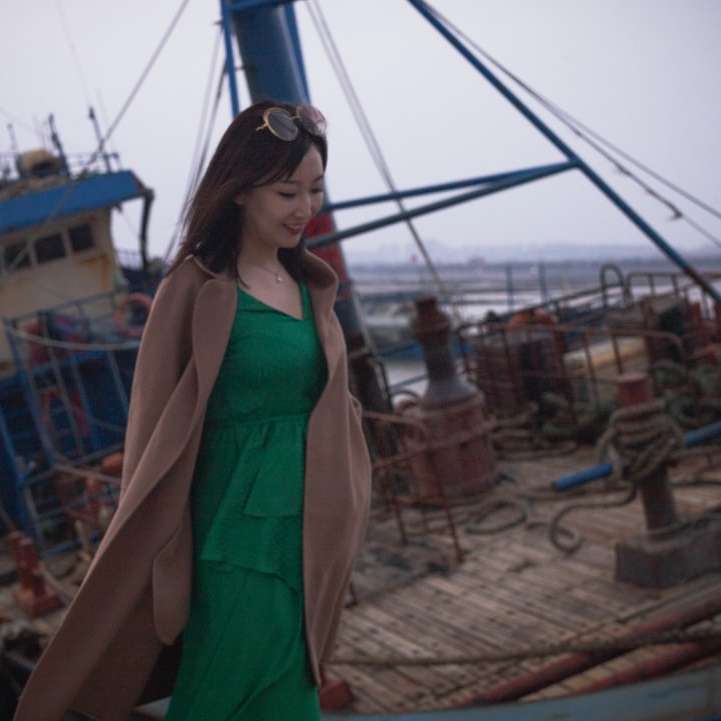 茶色の砂の上に立っている緑のノースリーブのドレスの女性 スライディングパズル・オンライン