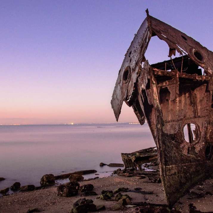 navio de madeira marrom na costa do mar durante o dia puzzle deslizante online