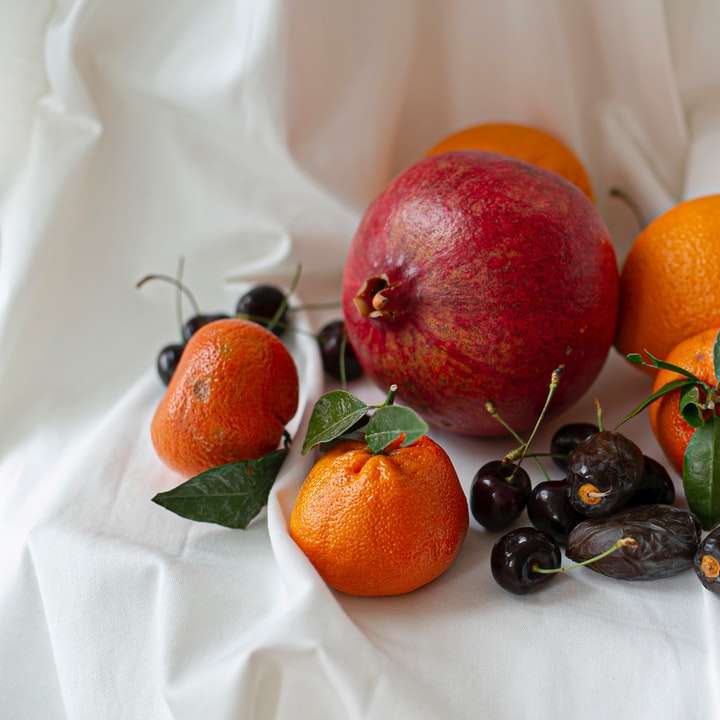 оранжевые фрукты и черные ягоды на белой ткани раздвижная головоломка онлайн