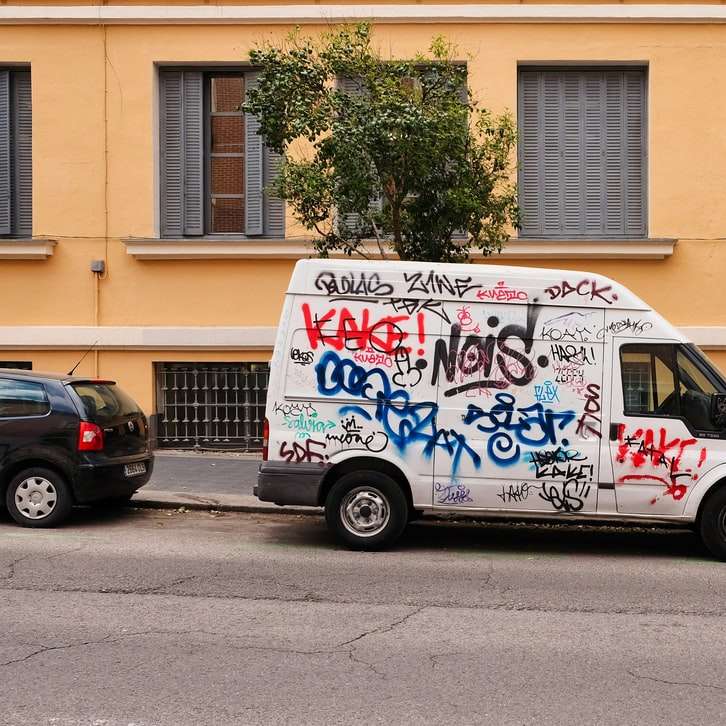 Camioneta blanca, azul y roja estacionada junto al edificio marrón puzzle deslizante online