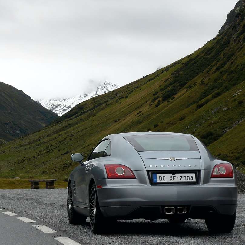 silbernes Auto auf der Straße in der Nähe von grünen Bergen tagsüber Online-Puzzle