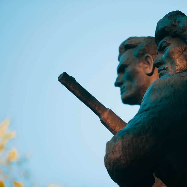 uomo che tiene la statua del bastone durante il giorno puzzle online
