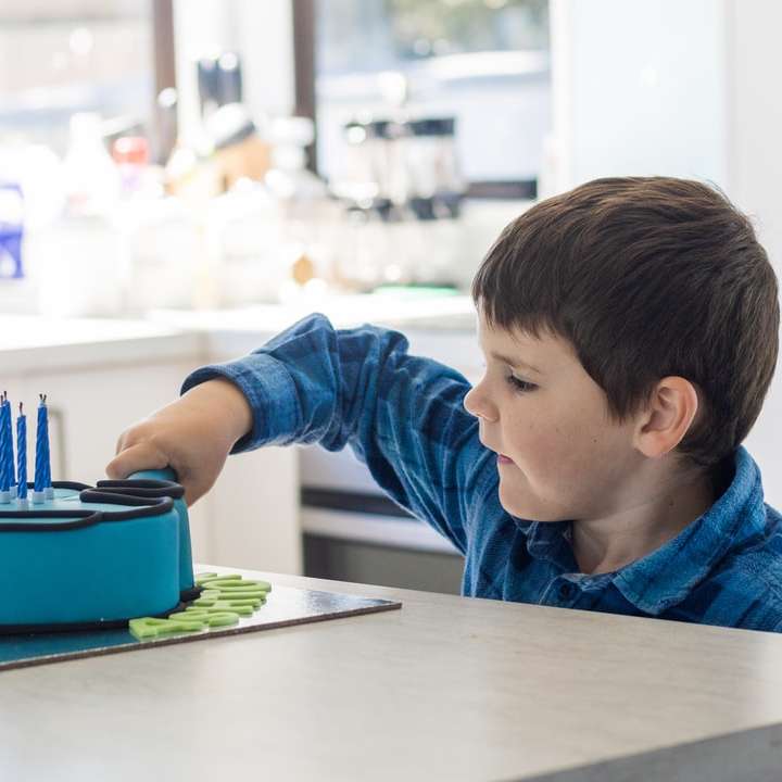 chlapec v modré košili s dlouhým rukávem sedí na židli online puzzle
