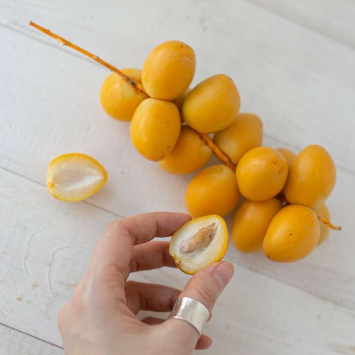 person holding yellow round fruits sliding puzzle online
