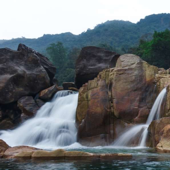 водопади между кафява скалиста планина през деня онлайн пъзел