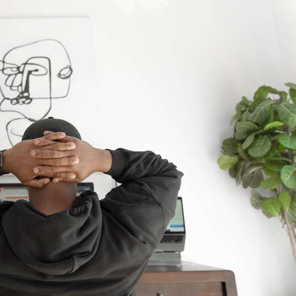 Mann im grauen Hoodie sitzt auf Stuhl Schiebepuzzle online