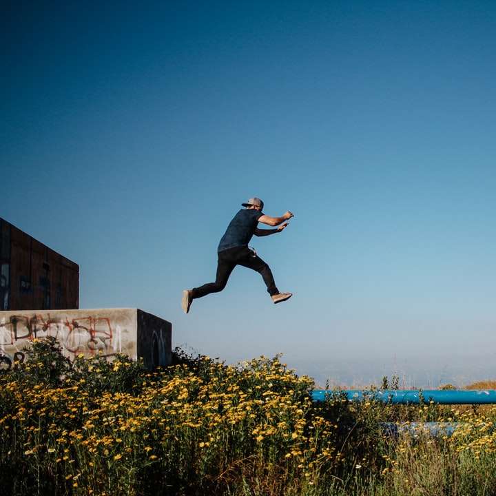 чоловік у чорній футболці і чорних шортах стрибає розсувний пазл онлайн