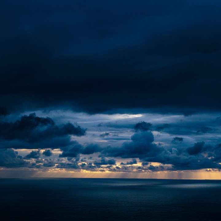 синьо море под синьо и бяло облачно небе през деня плъзгащ се пъзел онлайн