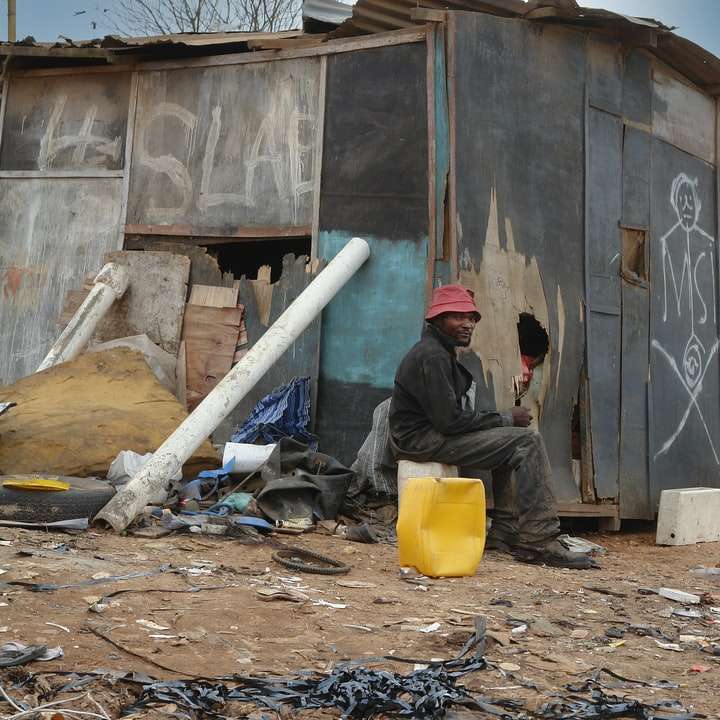 άνδρας με μαύρο σακάκι κάθεται στο έδαφος κοντά στα σκουπίδια συρόμενο παζλ online