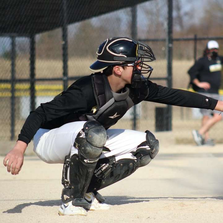 Hombre de chaqueta y pantalón blanco y negro jugando béisbol rompecabezas en línea