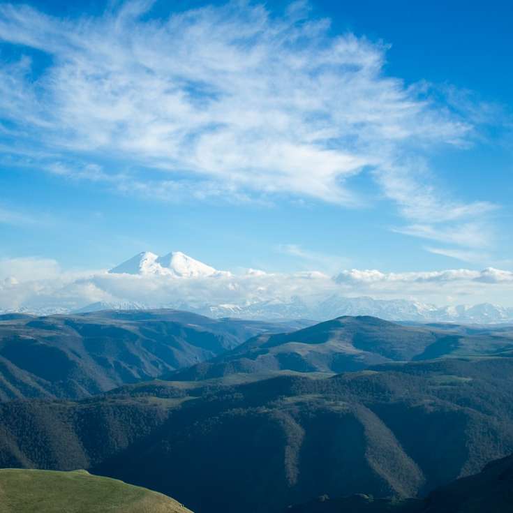 munți verzi sub cer albastru în timpul zilei alunecare puzzle online