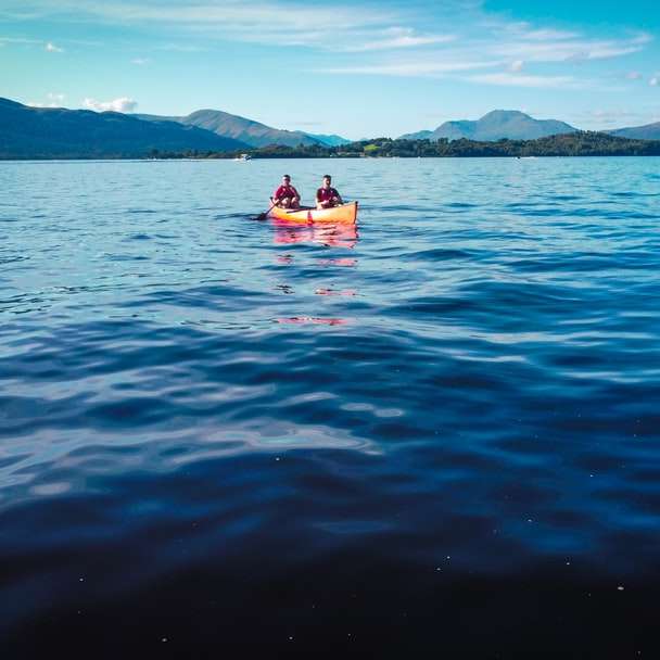 2 persoane călare pe o barcă roșie pe mare în timpul zilei puzzle online
