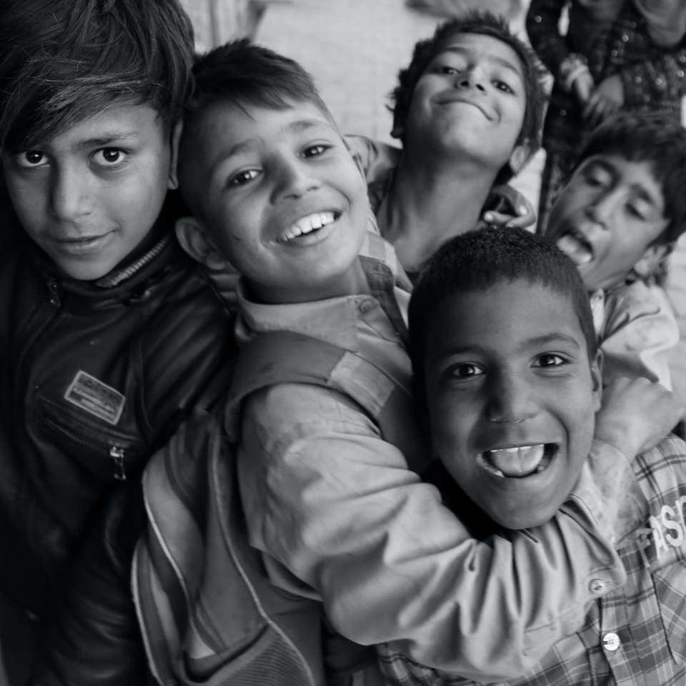 foto en escala de grises de 3 niños sonriendo rompecabezas en línea