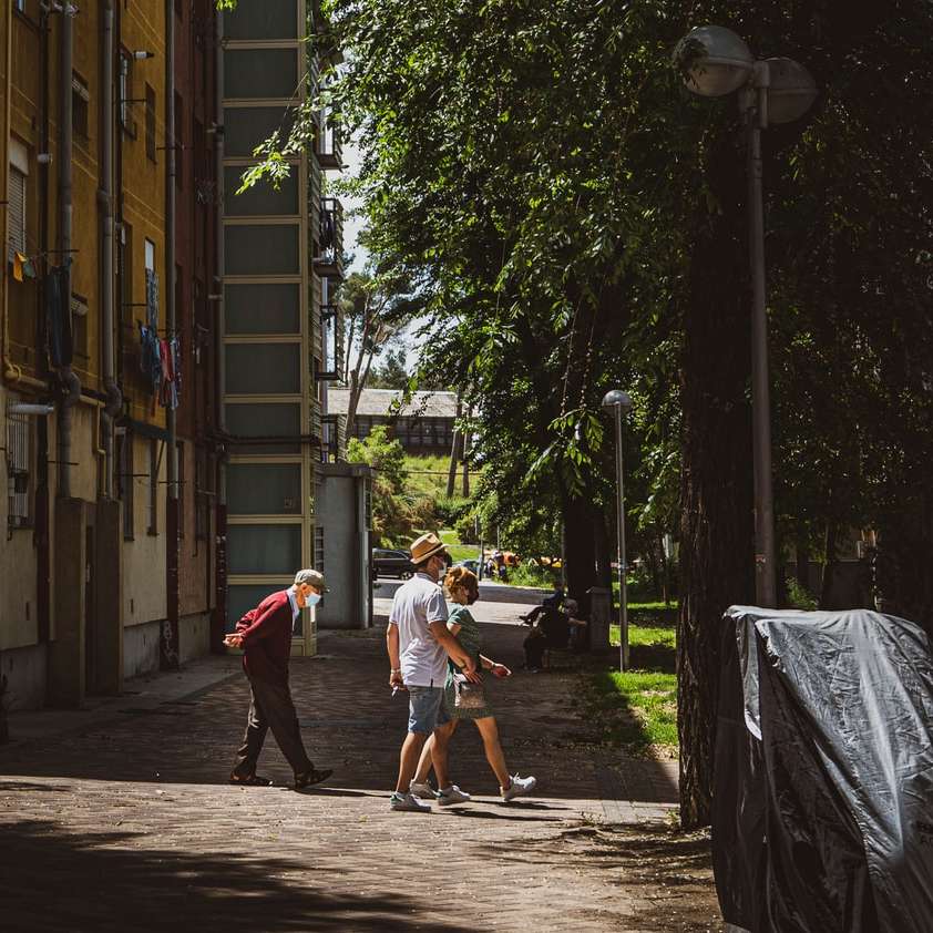 homme en t-shirt blanc et short marron marchant sur le trottoir puzzle en ligne