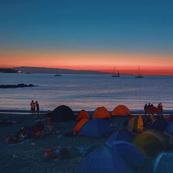 människor på stranden under solnedgången Pussel online