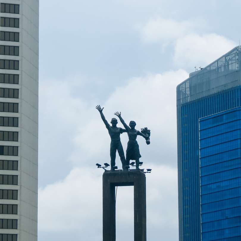 Estátua preta do homem em cima do edifício puzzle deslizante online