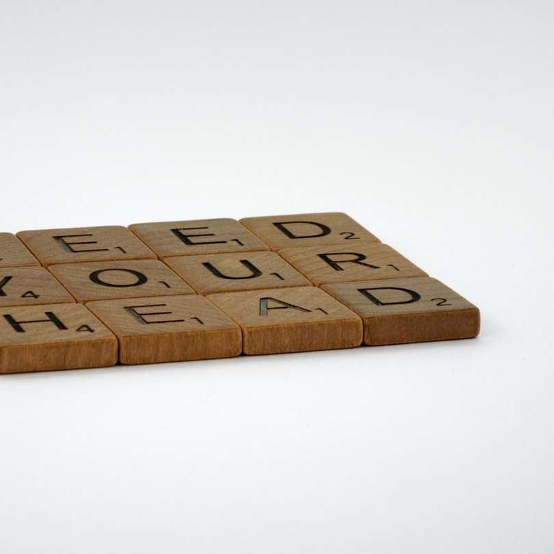 brązowe drewniane klocki z literami na białej powierzchni puzzle online
