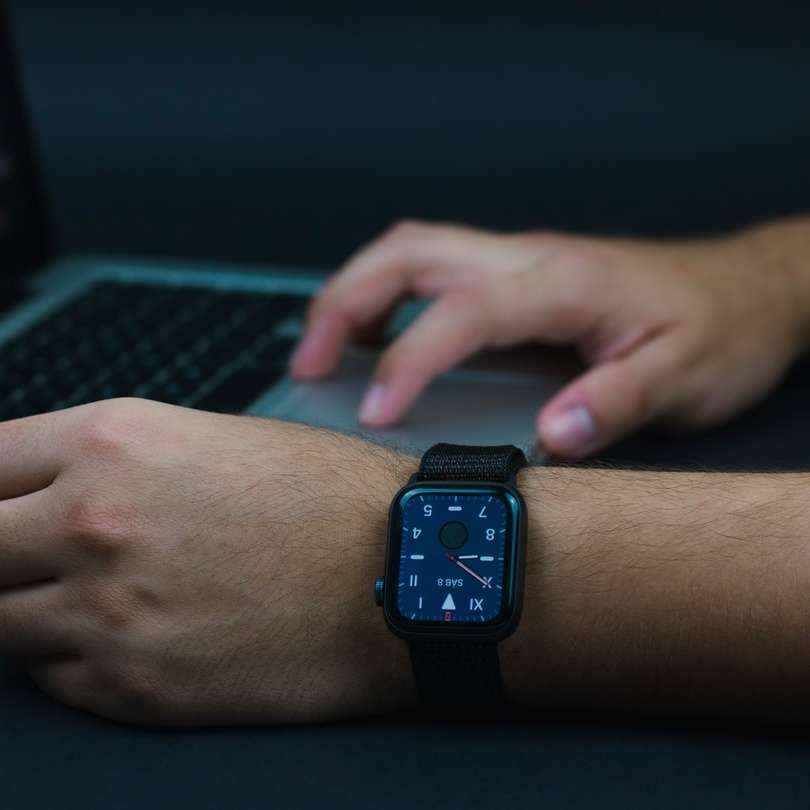 човек, носещ черен часовник с ябълка с черна спортна лента плъзгащ се пъзел онлайн