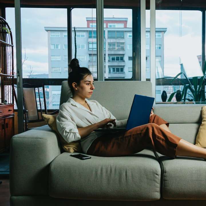 женщина в белой рубашке с длинным рукавом сидит на белом диване онлайн-пазл