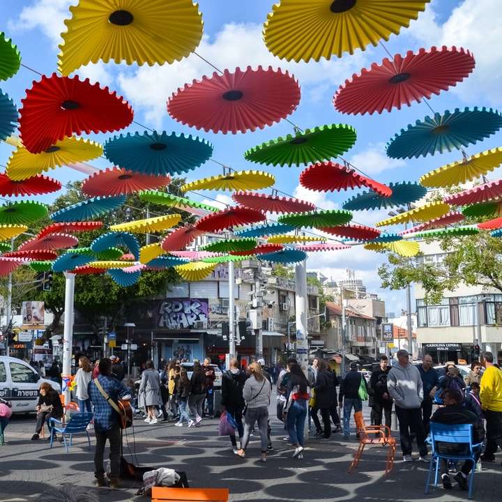 ludzie chodzą po ulicy z żółtym i czerwonym parasolem puzzle przesuwne online