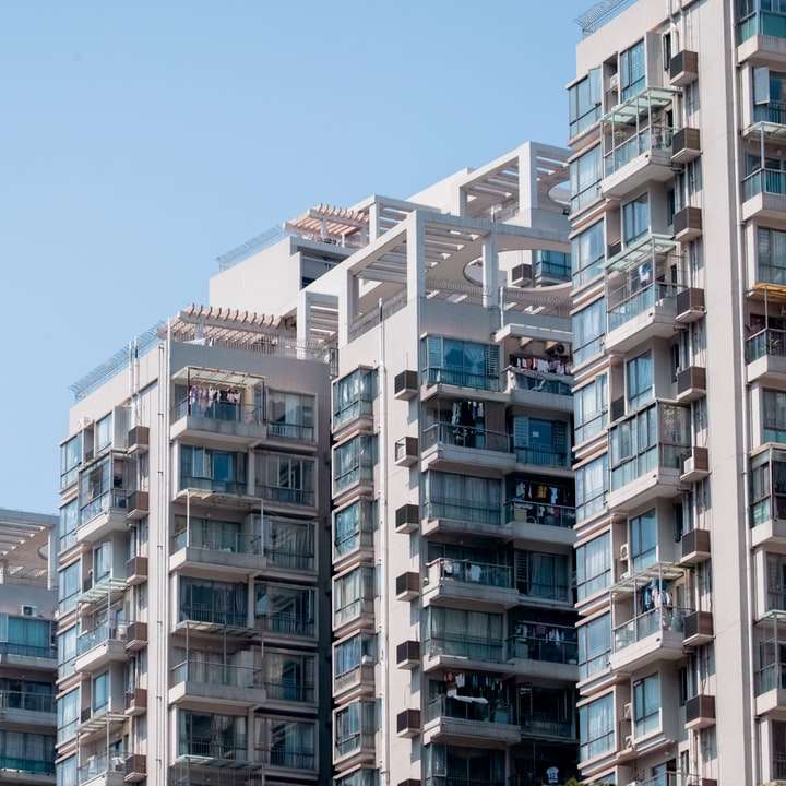 bílá a hnědá betonová budova pod modrou oblohou posuvné puzzle online